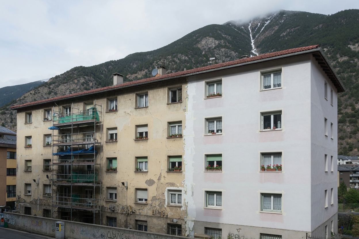 Bloc d'habitatges a Andorra, meitat pintada i meitat pendent. Fotografia de referència.